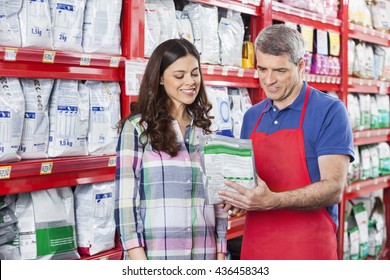 Salesman Assisting Customer In Buying Pet Food At Store