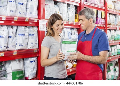 Salesman Assisting Customer In Buying Pet Food At Shop