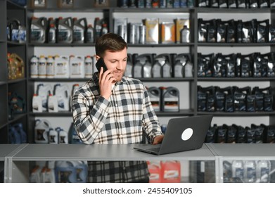 A salesman in an auto parts store is talking to a customer on the phone. - Powered by Shutterstock