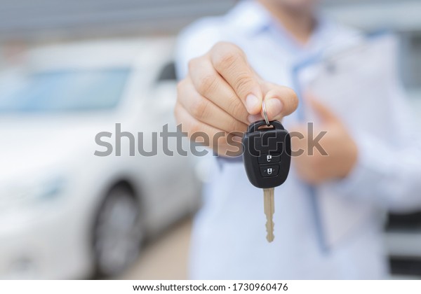 Salesman is\
carrying the car keys delivered to the customer at the showroom\
with a low interest offer. Special\
promotion