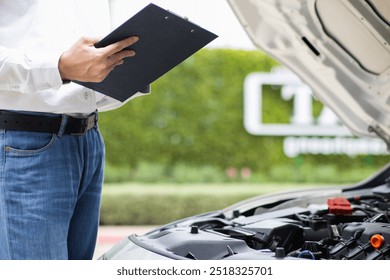 salesman is checking condition of car before delivering it to customer to ensure the quality and service after agreeing to sales contract. concept of checking the condition of the car for confidence