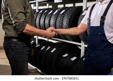 Salesman And Customer Shaking Hands In Auto Service Shop, Male Made Choice, Buying Car Tire For Winter