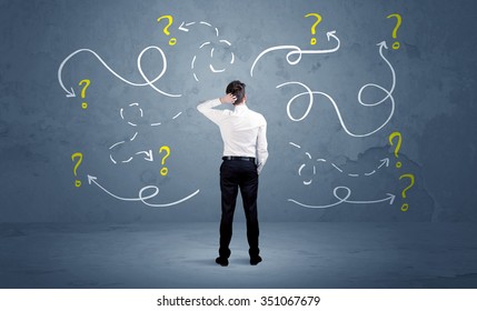 A salesman in doubt can not find the solution to the problem concept with curvy lined arrows and question marks drawn on urban wall - Shutterstock ID 351067679