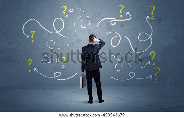 A salesman in doubt can not find the solution to the\
problem concept with curvy lined arrows and question marks drawn on\
urban wall