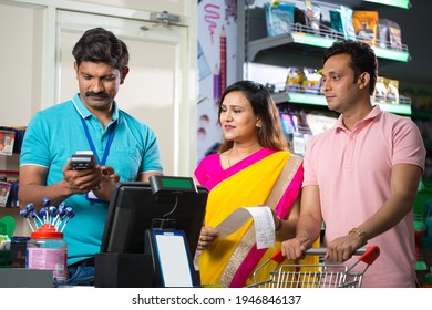 Salesman Explaining Product Details To Couple Shopping At Grocery Store