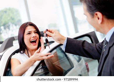 Salesman Handling Keys To A Woman After Buying A Car