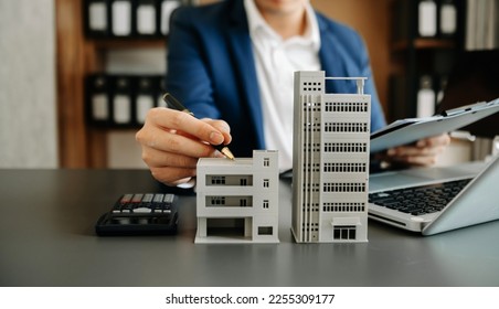 Salesman Hands On House Model , Small Toy House Small Mortgage Property insurance and concepts real estate
