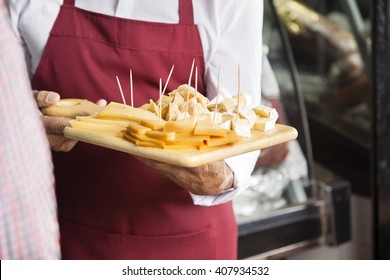 Salesman Holding Cutting Board With Assorted Cheese - Shutterstock ID 407934532