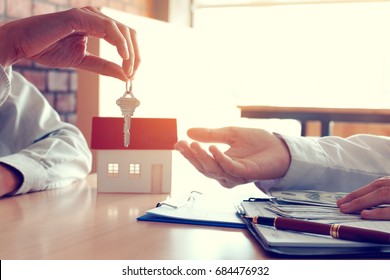 Salesman home brokers provide key to new homeowners and buyers giving money for salesman.