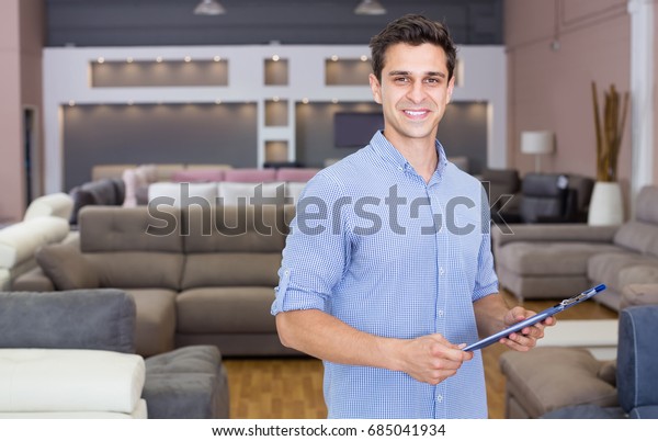 Salesman showing prices in home furnishings store