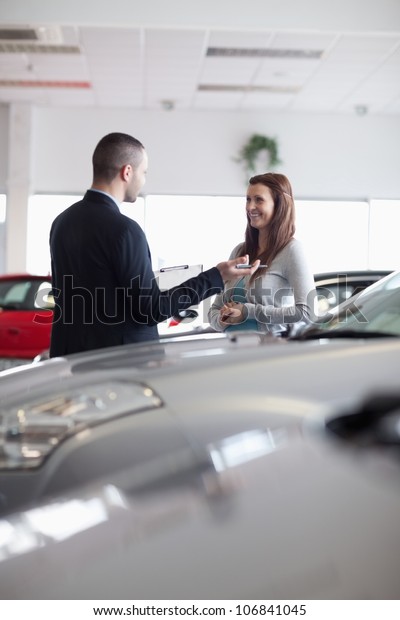 Salesman speaking\
with a woman in a\
dealership