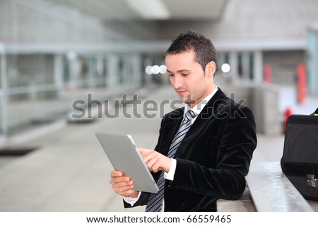 Salesman stannnding oustide with electronic tablet