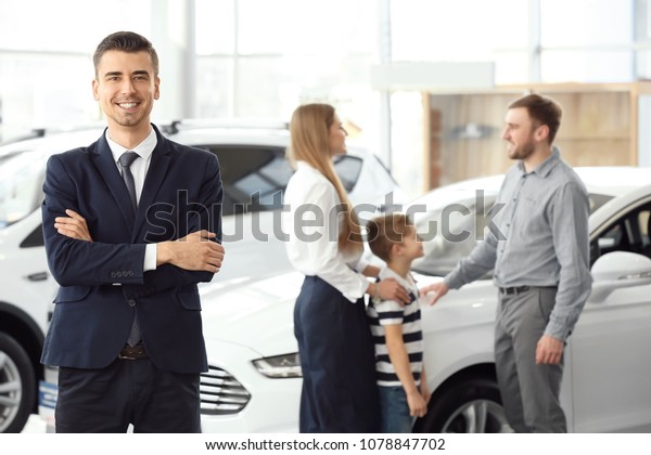 Salesman and young family\
in car salon