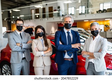 Salespeople With Protective Face Masks Working At Car Showroom. Covid 19, Coronavirus Concept.