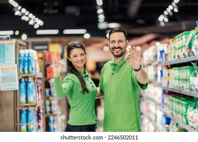 A salespeople are showing okay gesture at the camera and smiling at it. - Powered by Shutterstock