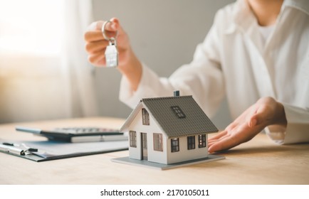 Salesperson Concept Of Holding House Keys, House Keys For A New Home, New Home Purchase. A Loan Agreement For Real Estate, A Loan Deal For Real Estate, A Loan Agreement For Real Estate