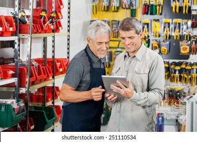 Salesperson And Customer Using Tablet Computer In Hardware Store