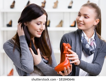 Salesperson Offers Footwear For The Female Customer In The Shopping Center