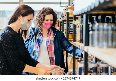 Salesperson In Protective Mask Helps A Pregnant Woman At A Wholesale Food Store. The Seller Advises The Buyer On Purchasing Plastic-free Products In A Waste-free Store. Support Small Local Businesses.