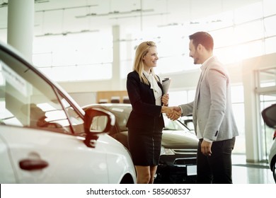 Salesperson selling cars at car dealership
