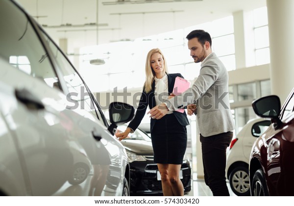 Salesperson selling cars\
at car dealership