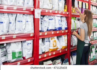 Saleswoman Arranging Food Packages In Pet Store