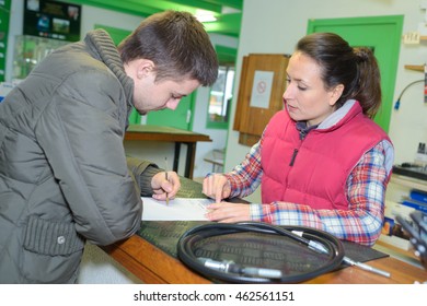 Saleswoman And Client At Cash Counter In Hardware Store