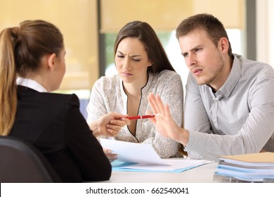 Saleswoman offering a pen to a couple of angry customers that rejects to sing a contract at office