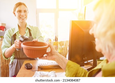 Saleswoman With Scanner Scans Item Number At Checkout From Hardware Store