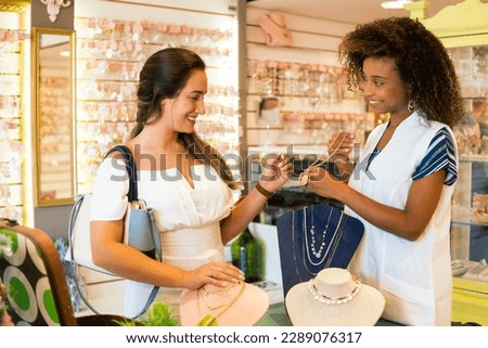 Saleswoman shows products to customer in jewelry store