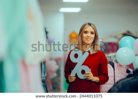 
Saleswoman in the Store Holding a Discount Sign Promoting best Deals. Happy promoter showing the boutique has great price reduction 
