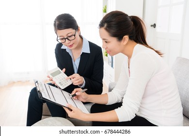 Saleswoman Using Calculator Counting House Insurance Money For Buyer When Smiling Girl Looking At Document Asking Question.