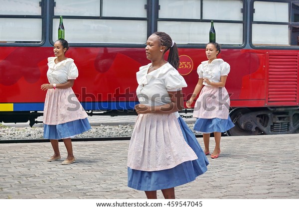 SALINAS, ECUADOR - CIRCA APRIL 2016:\
Afro-Ecuadorian women dance in front of the excursion train, at the\
station, with bottles on their\
heads