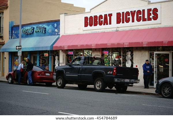 SALINAS,\
UNITED STATES - DECEMBER 22: Cars parked in the Monterey street in\
front of the bike shop Bobcat Bicycles and a pet store  on December\
22, 2015 in Salinas / Commercial Street\
Salinas