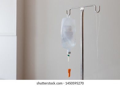 Saline Bag Hand On Stainless Steel Pole In Luxury Hospital. IV Fluid Treatment At Modern Home.