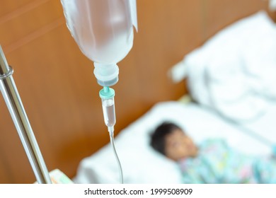 Saline intravenous (iv) drip in a children's patient hand, kid sick and sleep and equipment IV tube of Infusion pumps for patients in hospitals