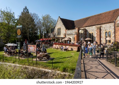 Salisbury, Wiltshire, UK. 2021.  The River Avon Flowing Past Customers Queueing And Eating Outside Bishops Mill Pub During Covid Lockdown. 