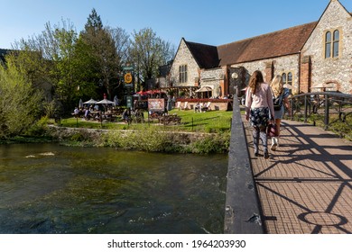 Salisbury, Wiltshire, UK. 2021.  The River Avon Flowing Past Customers Queueing And Eating Outside Bishops Mill Pub During Covid Lockdown. 