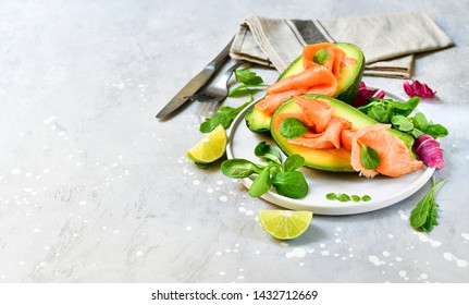 salmon and avocado salad with arugula and lime. on a white plate. healthy lunch. ketogenic diet  food (keto diet). 