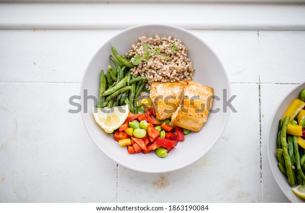 Salmon and buckwheat dish with green beans,\
broad beans, and tomato slices from above. Nutritious dish with\
vegetables and fish. Healthy balanced\
diet