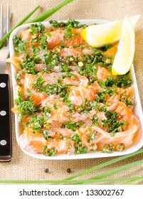 Salmon carpaccio - fresh salmon slices in marinade on burlapsack