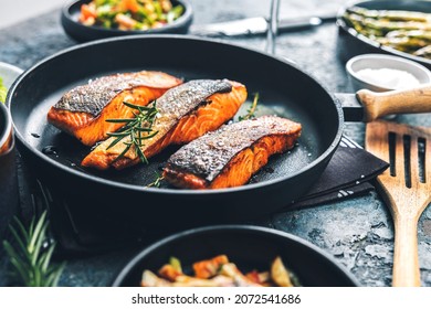 Salmon fillets and herb decoration in an old frying pan. - Shutterstock ID 2072541686
