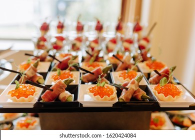 Salmon Fish Caviar In Pastry Bowl And Sliced Meat With Green Sparge. Delicious Tasty Snacks Assortment On Table Closeup Photography Blurred Background. Appetizing Nutrition Catering Service