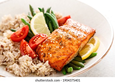 Lachs Fischfilet gebacken, Reis, grüne Bohnen und Tomaten in Lunchschüssel. Gesunde Lebensmittel