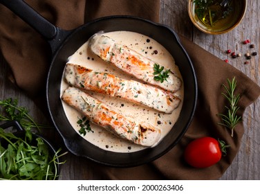 Salmon fish fillets with creamy sauce in frying pan