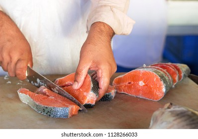 Salmon fish with sharp knife on the cutting board at Waterfront fish Market,Deira Dubai,UAE