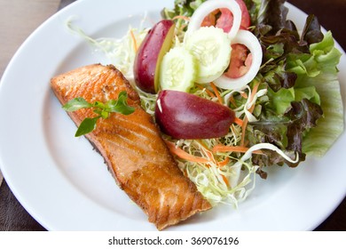 Salmon fish steak with  Vegetable salad on plate.