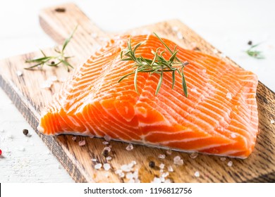 Salmon fish. Uncooked salmon fillet with lemon sea salt and rosemary on white. Close up.