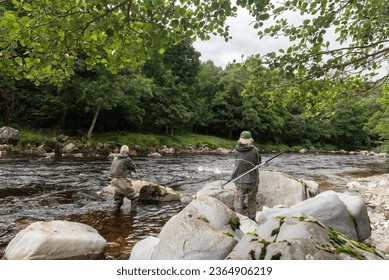 Salmon fisherman with his grille casting his fly into the Avon River, Moray, Scotland, United Kingdom.  - Powered by Shutterstock