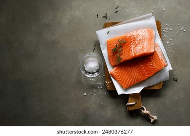 Salmon. Fresh raw salmon fish fillet with cooking ingredients on dark background, top view